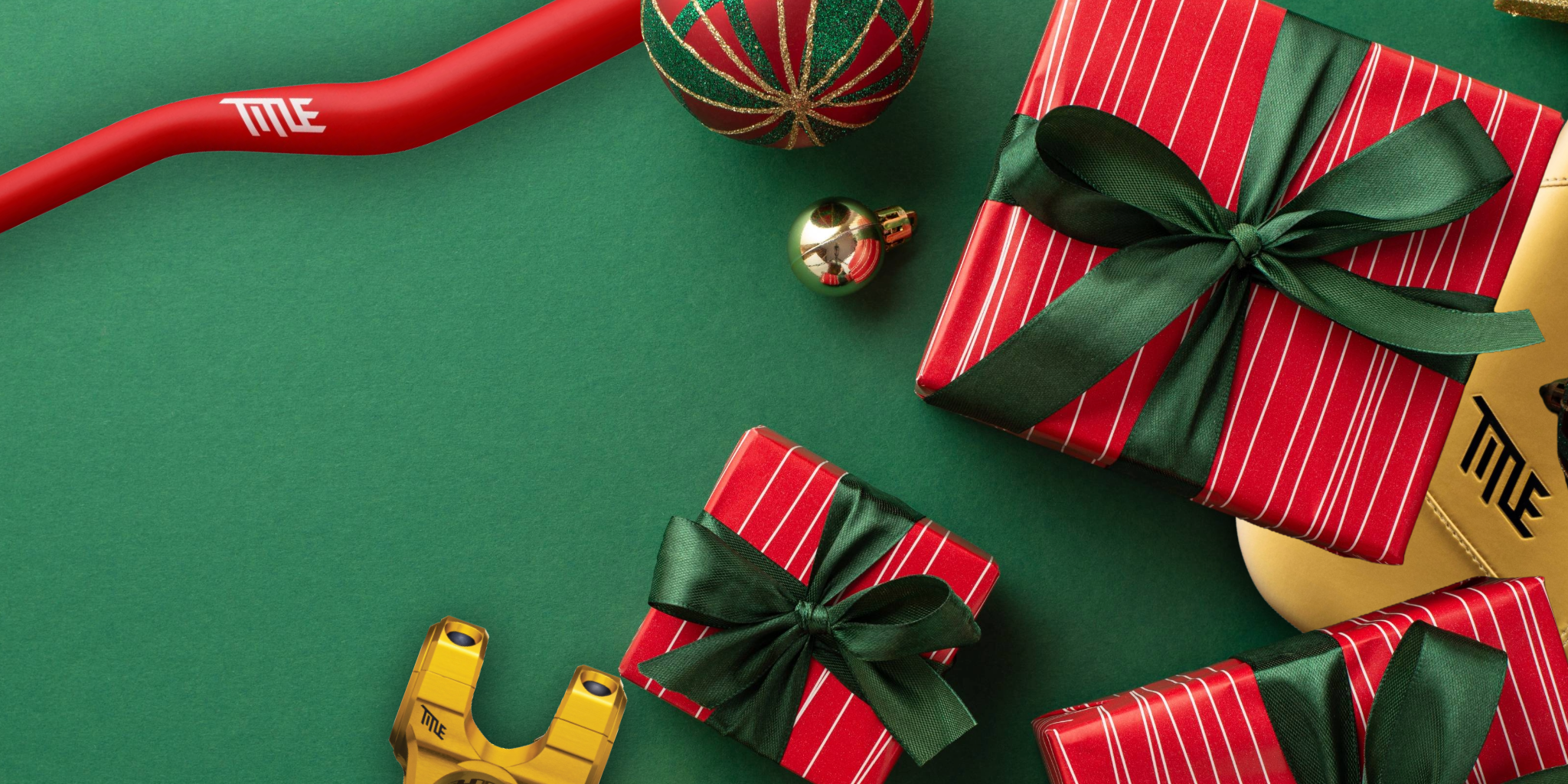 Red and green gift boxes with ribbons on a green surface