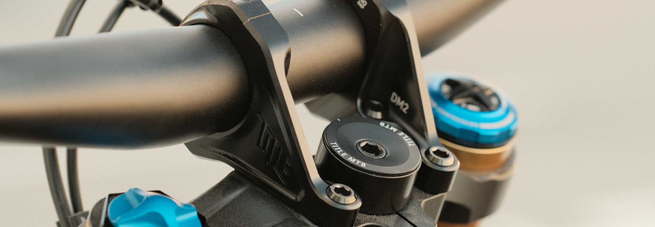 Close-up of a bicycle handlebar with black and blue components on a blurred background