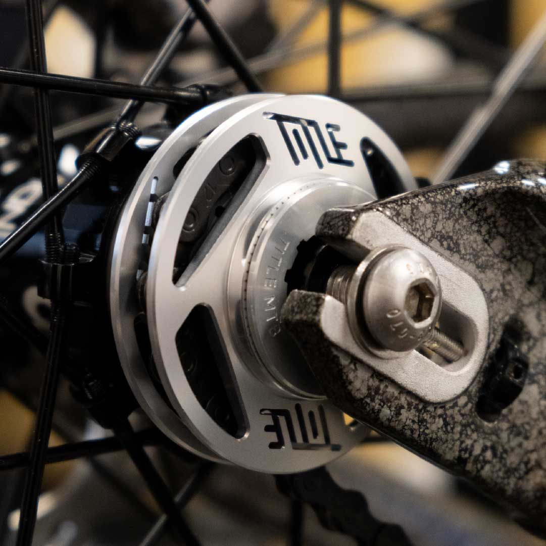 Close-up of a bicycle hub with 'Title' branding on a blurred background