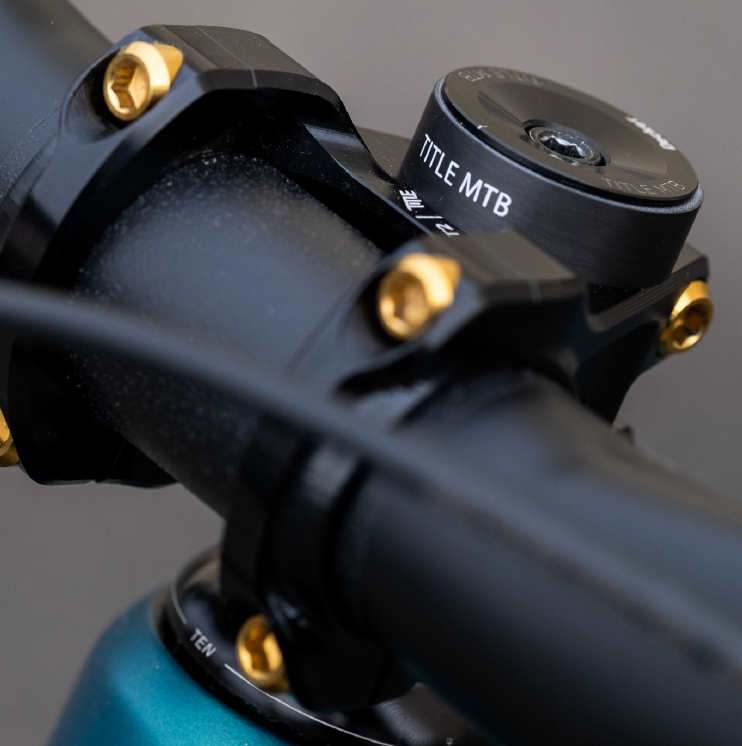 Close-up of a bicycle handlebar with 'TITLE MTB' branding on a gray background