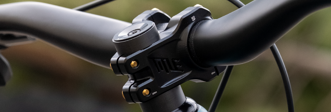 Close-up of a bike handlebar with a control unit on a blurred natural background