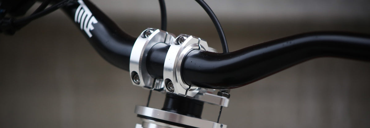 Close-up of a bicycle handlebar with a chrome stem on a blurred background