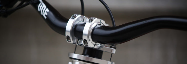 Close-up of a bicycle handlebar with a chrome stem on a blurred background
