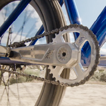 Close-up of a bicycle chain and gear system with a blurred natural background